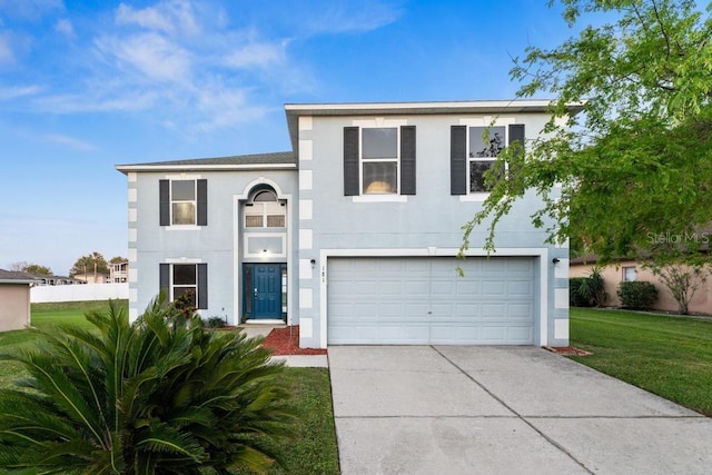 view of front of house featuring stucco siding, a front yard, a garage, and driveway