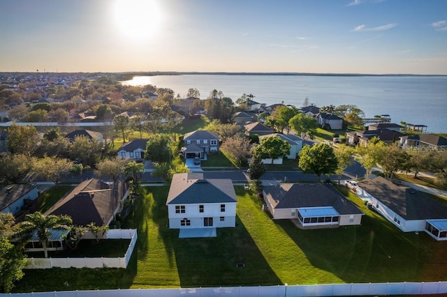 aerial view at dusk featuring a residential view and a water view