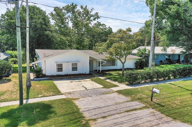 single story home featuring stucco siding, concrete driveway, and a front yard