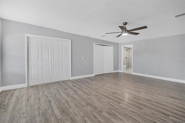 unfurnished bedroom with visible vents, baseboards, and wood finished floors