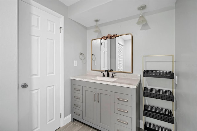 bathroom with baseboards, wood finished floors, and vanity