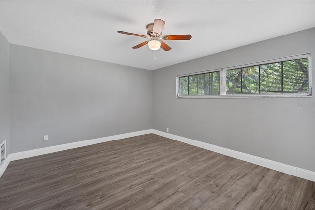 spare room with wood finished floors, baseboards, and ceiling fan