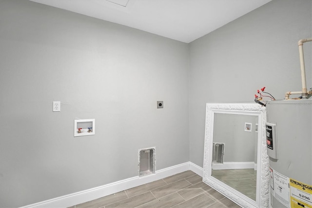 washroom with baseboards, hookup for an electric dryer, laundry area, water heater, and washer hookup