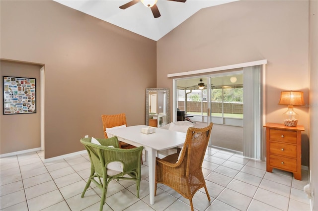 dining space with ceiling fan, baseboards, high vaulted ceiling, and light tile patterned flooring