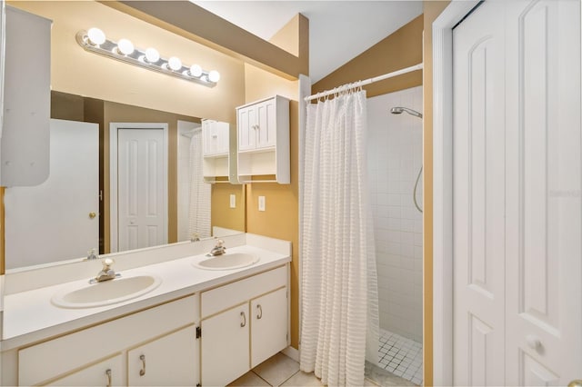 bathroom featuring vaulted ceiling, tiled shower, tile patterned floors, and a sink