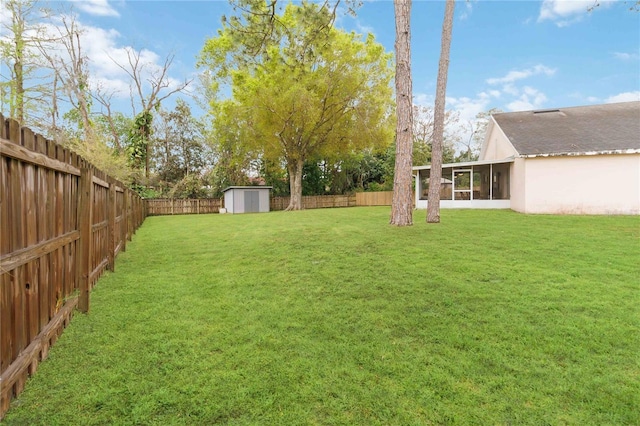 view of yard featuring an outdoor structure, a storage shed, a fenced backyard, and a sunroom