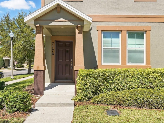 view of exterior entry with stucco siding