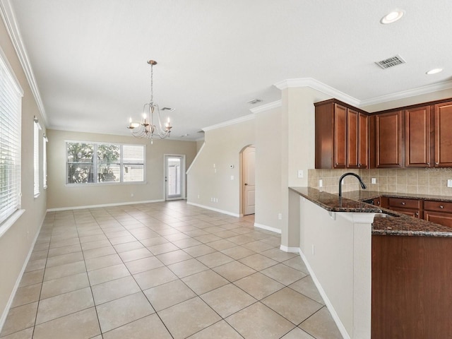 kitchen with a chandelier, decorative backsplash, and ornamental molding