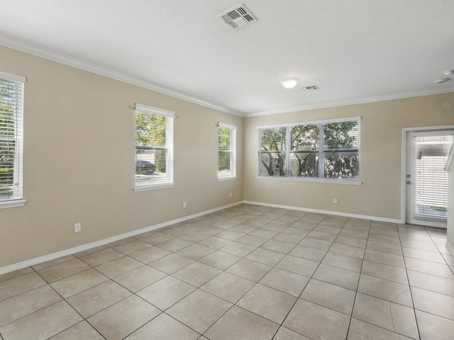 empty room featuring visible vents, plenty of natural light, and crown molding