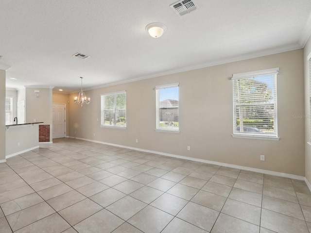 empty room with crown molding, a notable chandelier, visible vents, and plenty of natural light