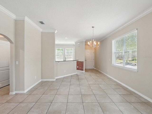 empty room with visible vents, arched walkways, a notable chandelier, and crown molding