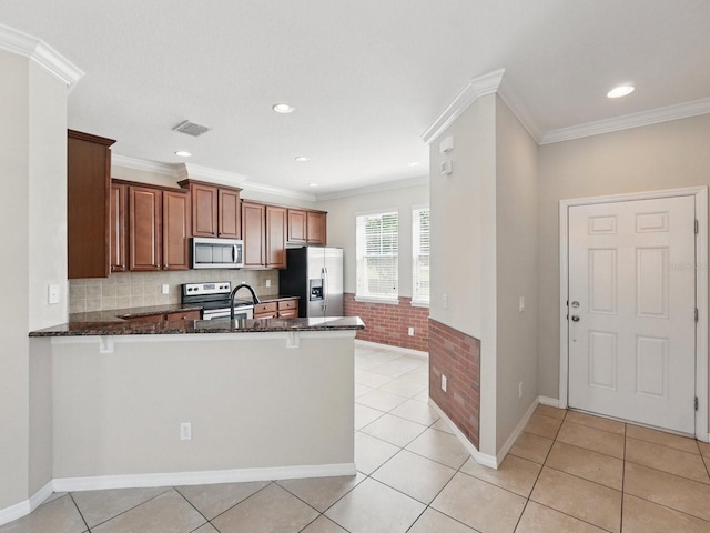 kitchen featuring dark stone counters, a peninsula, visible vents, and appliances with stainless steel finishes