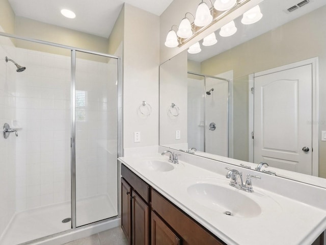 bathroom featuring tile patterned flooring, visible vents, a shower stall, and a sink