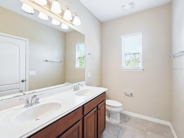 bathroom with tile patterned floors, toilet, double vanity, and a sink