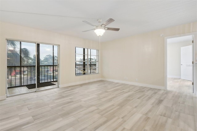 spare room with light wood-style flooring, baseboards, and ceiling fan