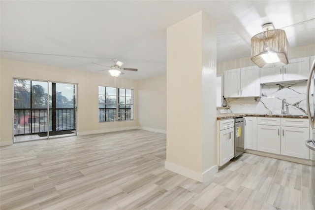 kitchen featuring light wood finished floors, backsplash, white cabinets, and dishwasher