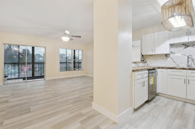 kitchen featuring open floor plan, backsplash, white cabinetry, and stainless steel dishwasher