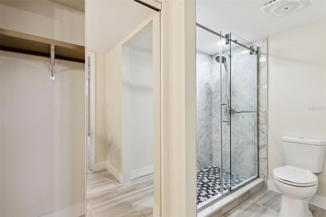 bathroom with toilet, baseboards, visible vents, and a marble finish shower