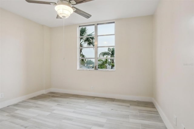 empty room featuring a ceiling fan and baseboards