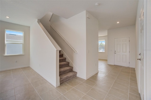 stairs with tile patterned floors, recessed lighting, and baseboards