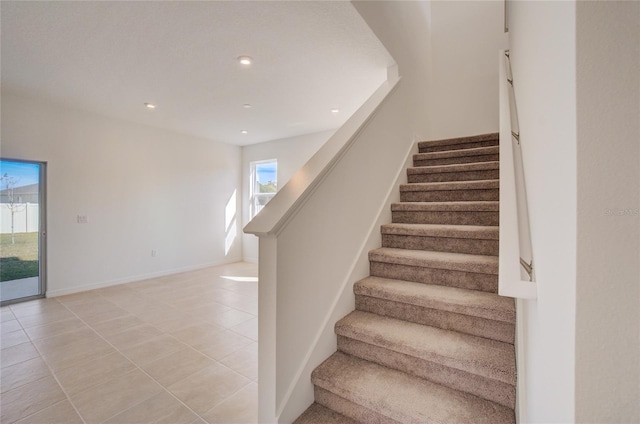 staircase with tile patterned floors, baseboards, and recessed lighting