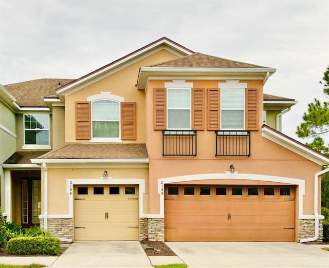 view of front of home with stucco siding, stone siding, and an attached garage