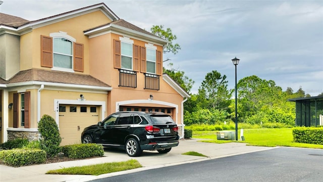 view of front of house featuring stucco siding, driveway, and a shingled roof