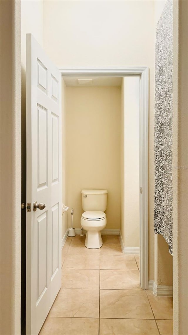 bathroom featuring tile patterned floors, toilet, and baseboards