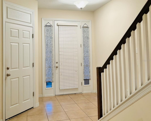 entrance foyer with stairs and light tile patterned flooring