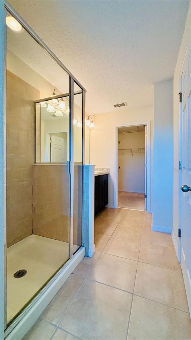 bathroom with visible vents, a stall shower, tile patterned floors, a textured ceiling, and vanity