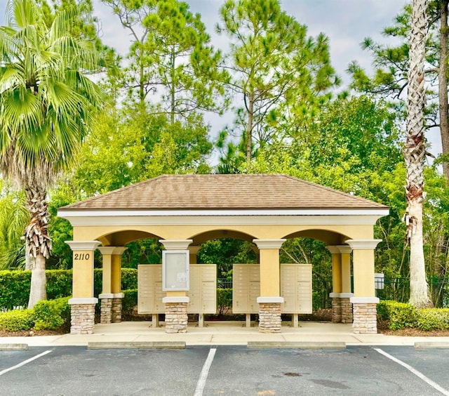 view of home's community featuring mail area and uncovered parking