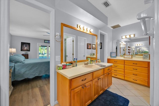 ensuite bathroom with vanity, ensuite bath, visible vents, and tile patterned floors