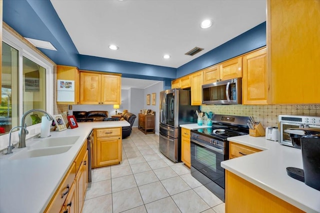 kitchen with visible vents, a sink, light countertops, appliances with stainless steel finishes, and tasteful backsplash