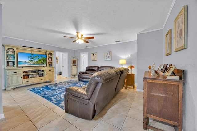 living room featuring a ceiling fan, baseboards, light tile patterned flooring, ornamental molding, and a textured ceiling