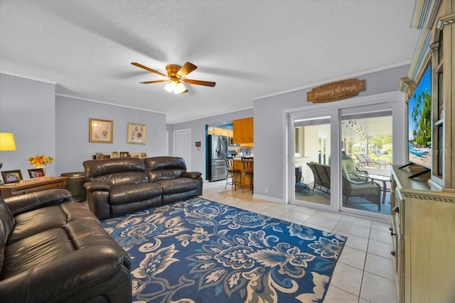 living room with crown molding, light tile patterned floors, a ceiling fan, and a textured ceiling