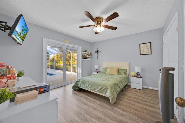 bedroom featuring wood finished floors, a ceiling fan, baseboards, and access to outside