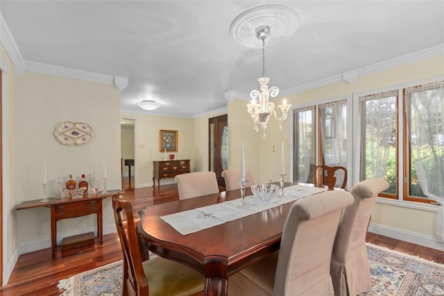 dining area with ornamental molding, an inviting chandelier, baseboards, and wood finished floors