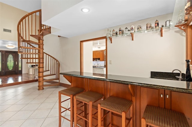 bar with stairway, light tile patterned flooring, baseboards, and visible vents