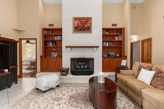 living area featuring light tile patterned floors, visible vents, and a high ceiling