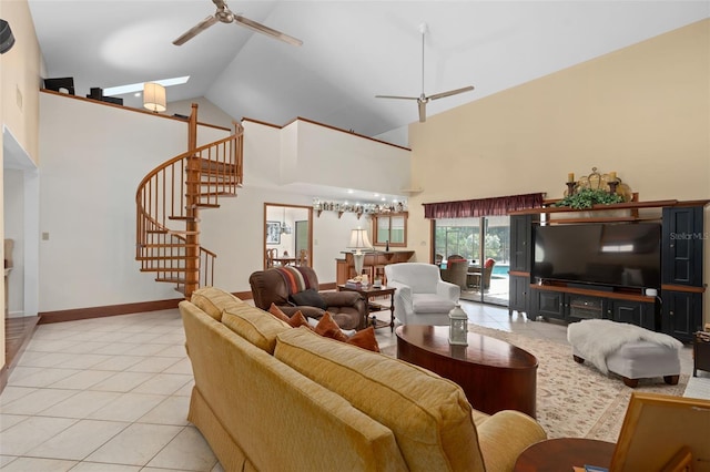 living area with high vaulted ceiling, a ceiling fan, light tile patterned floors, baseboards, and stairs