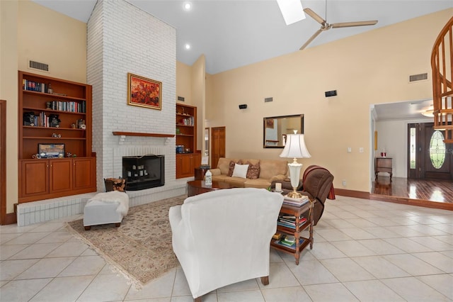 living area featuring high vaulted ceiling, light tile patterned flooring, visible vents, and built in features