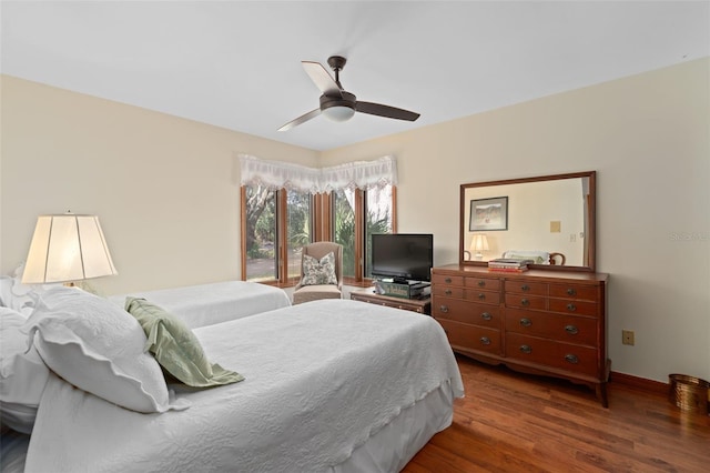 bedroom with baseboards, wood finished floors, and a ceiling fan