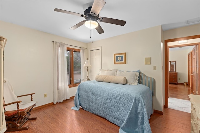 bedroom featuring light wood-style flooring, baseboards, and ceiling fan