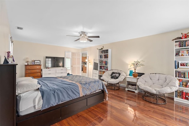 bedroom with a ceiling fan, wood finished floors, and visible vents