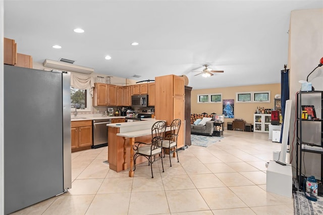 kitchen featuring light tile patterned flooring, ceiling fan, light countertops, appliances with stainless steel finishes, and open floor plan