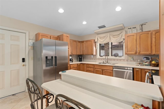 kitchen featuring visible vents, light countertops, light tile patterned floors, stainless steel appliances, and a sink