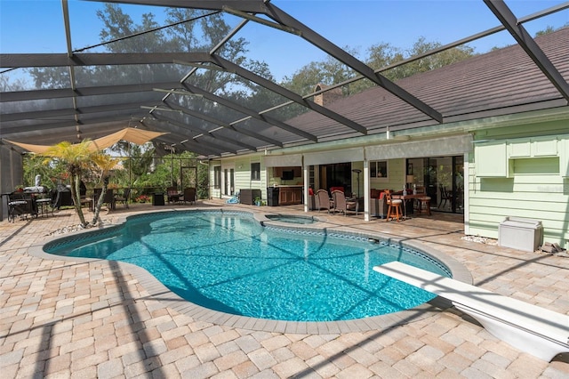 pool with a lanai, an in ground hot tub, and a patio