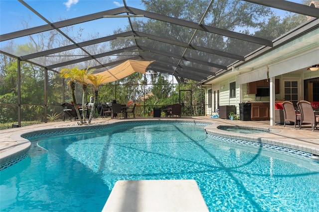 pool featuring glass enclosure, an in ground hot tub, a patio area, and a diving board