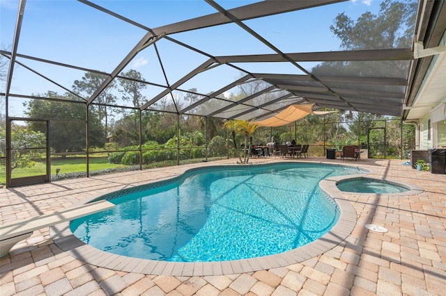 view of swimming pool featuring a lanai, a patio area, and a pool with connected hot tub