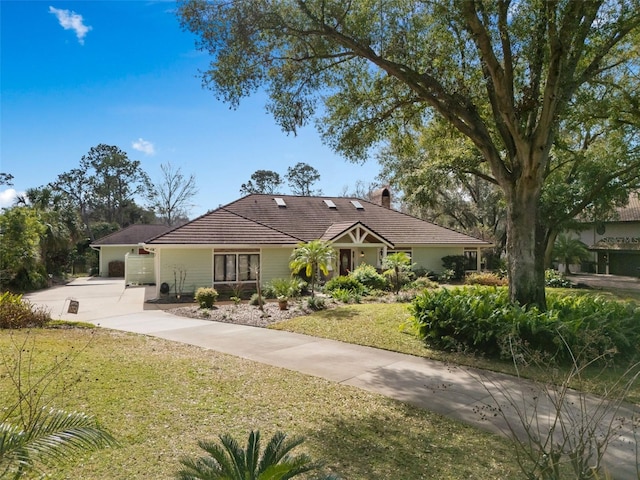 ranch-style house with a tiled roof, driveway, a chimney, and a front lawn